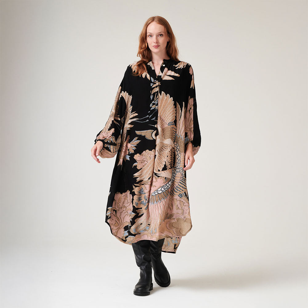 matt black crepe mid length dress with crane print in sand & light pink, worn with black boots