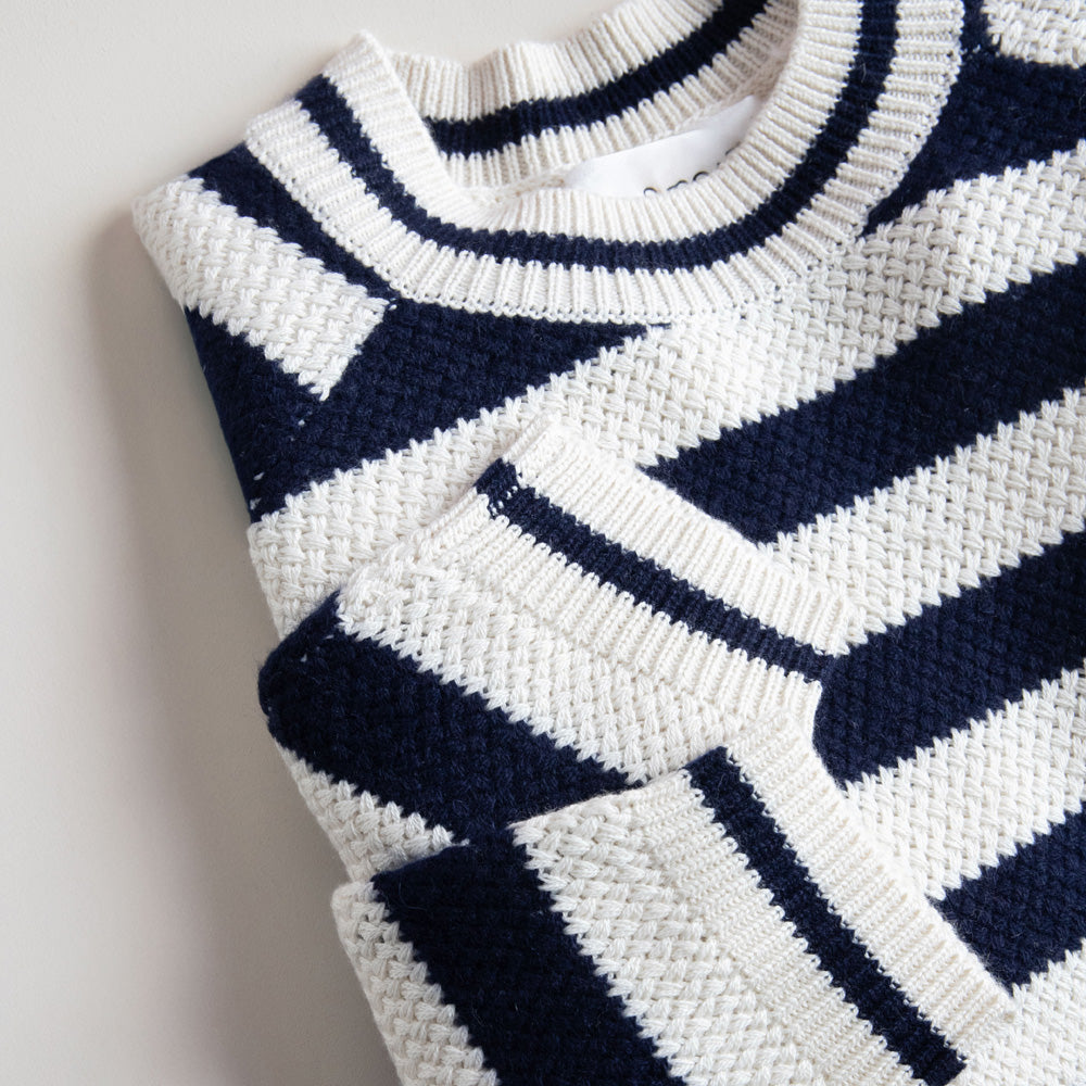 Close-up of a navy and white patterned sweater on a light background