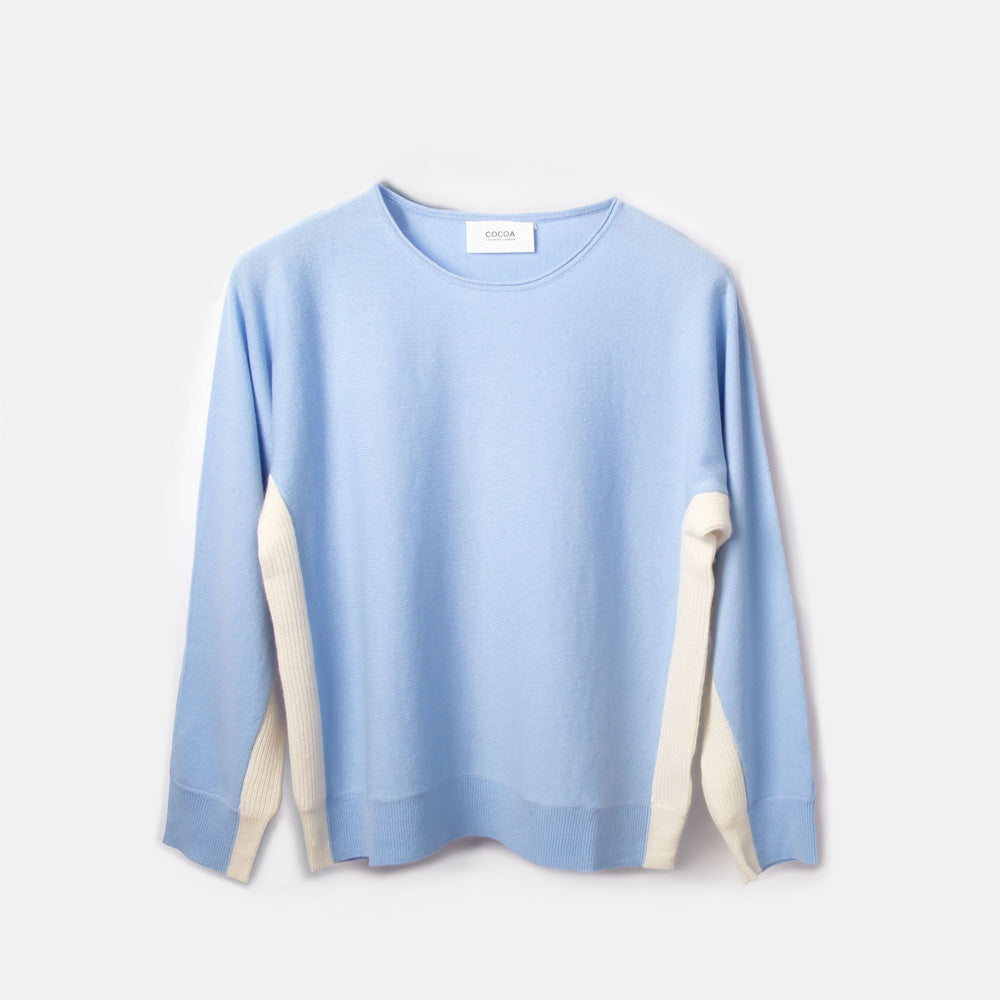 Light blue sweater with white accents on a light gray background