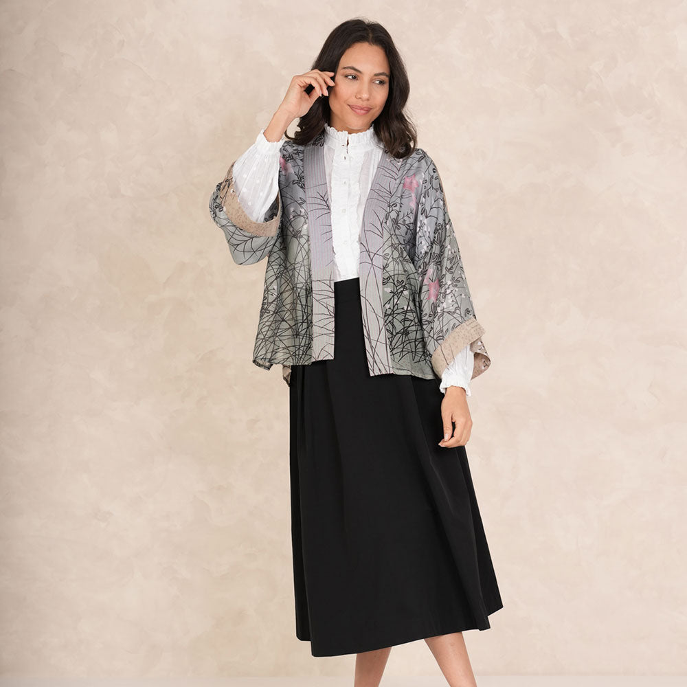 grey & green short kimono jacket with pink floral design, worn with white button through shirt and black skirt