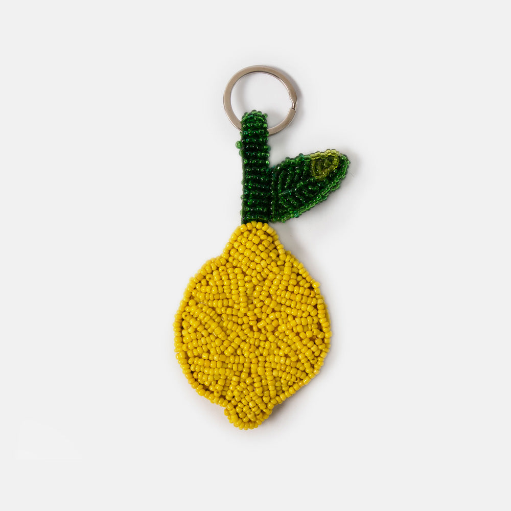 Beaded lemon keyring or bag charm with green leaves on a white background