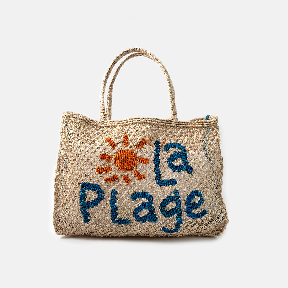 Jute shopper bag with embroidered 'la plage' text and sun design on a white background