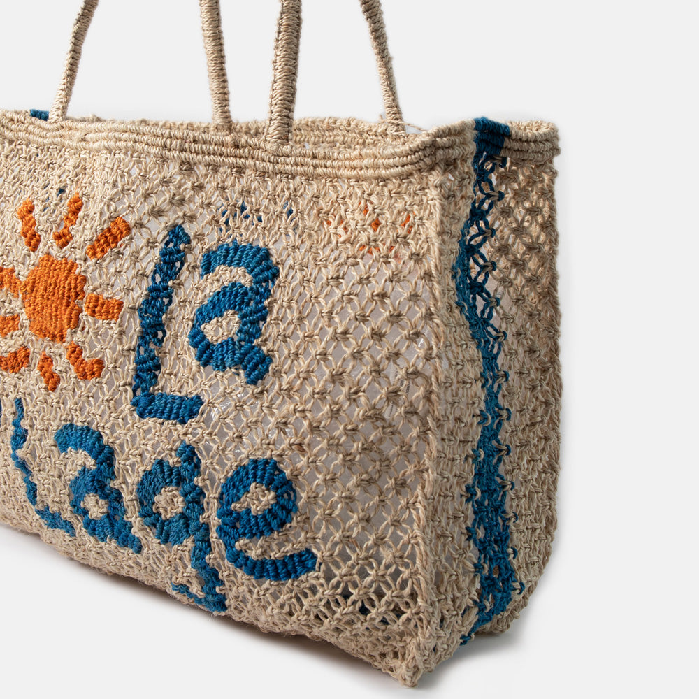 Jute bag with embroidered 'la plage' text and sun design on a white background