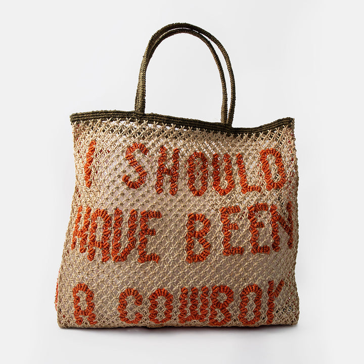natural jute shopper bag with the text 'i should have been a cowboy' in red, against a white background