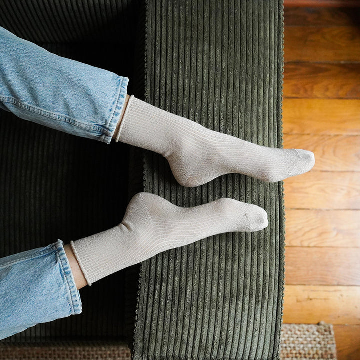 person wearing beige ribbed sparkly socks with light wash denim jeans