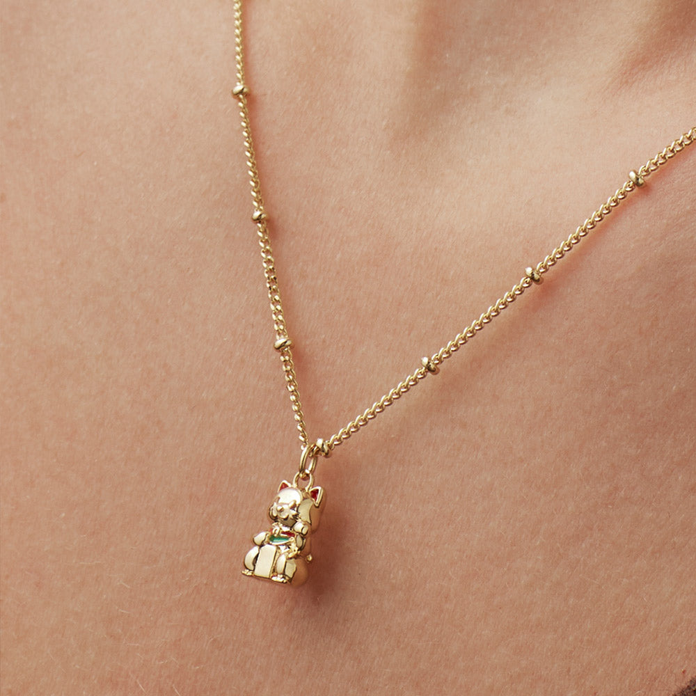 Woman wearing a gold necklace with a cat-shaped pendant