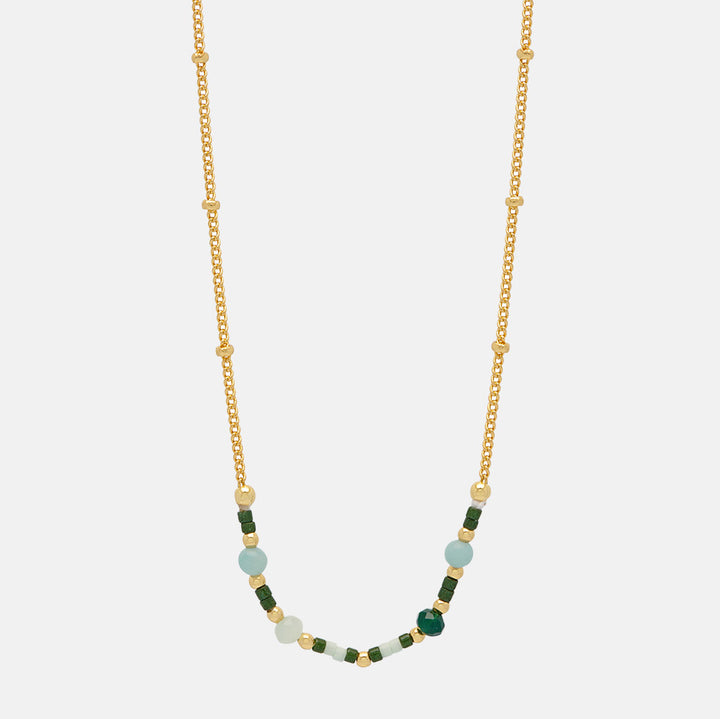 gold plated necklace with green enamel beads on a white background