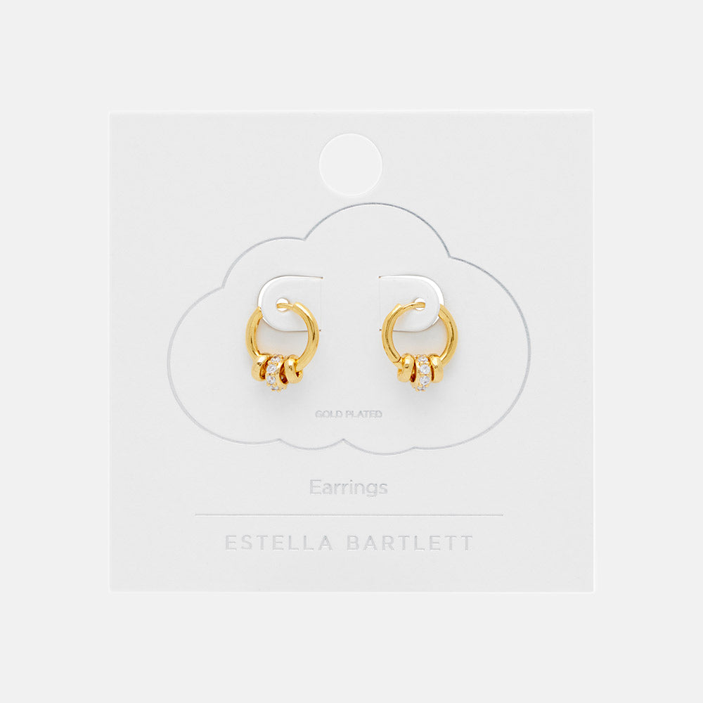 gold huggie hoop earrings with 3 gold discs, one set with cubic zirconia in white packaging