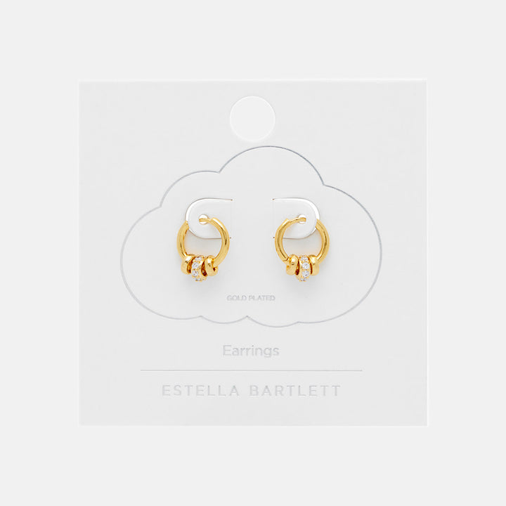 gold huggie hoop earrings with 3 gold discs, one set with cubic zirconia in white packaging