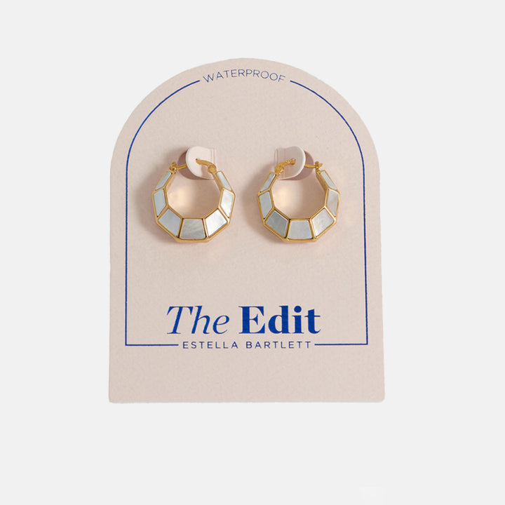 gold & mother of pearl octagonal hinge earrings in packaging on a light grey background
