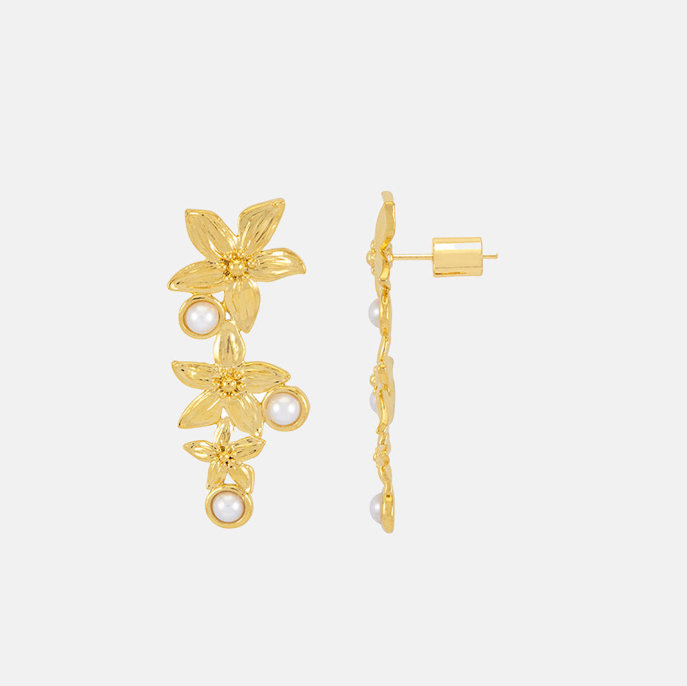 gold drop earrings with 3 flowers and 3 small pearls on a light grey background