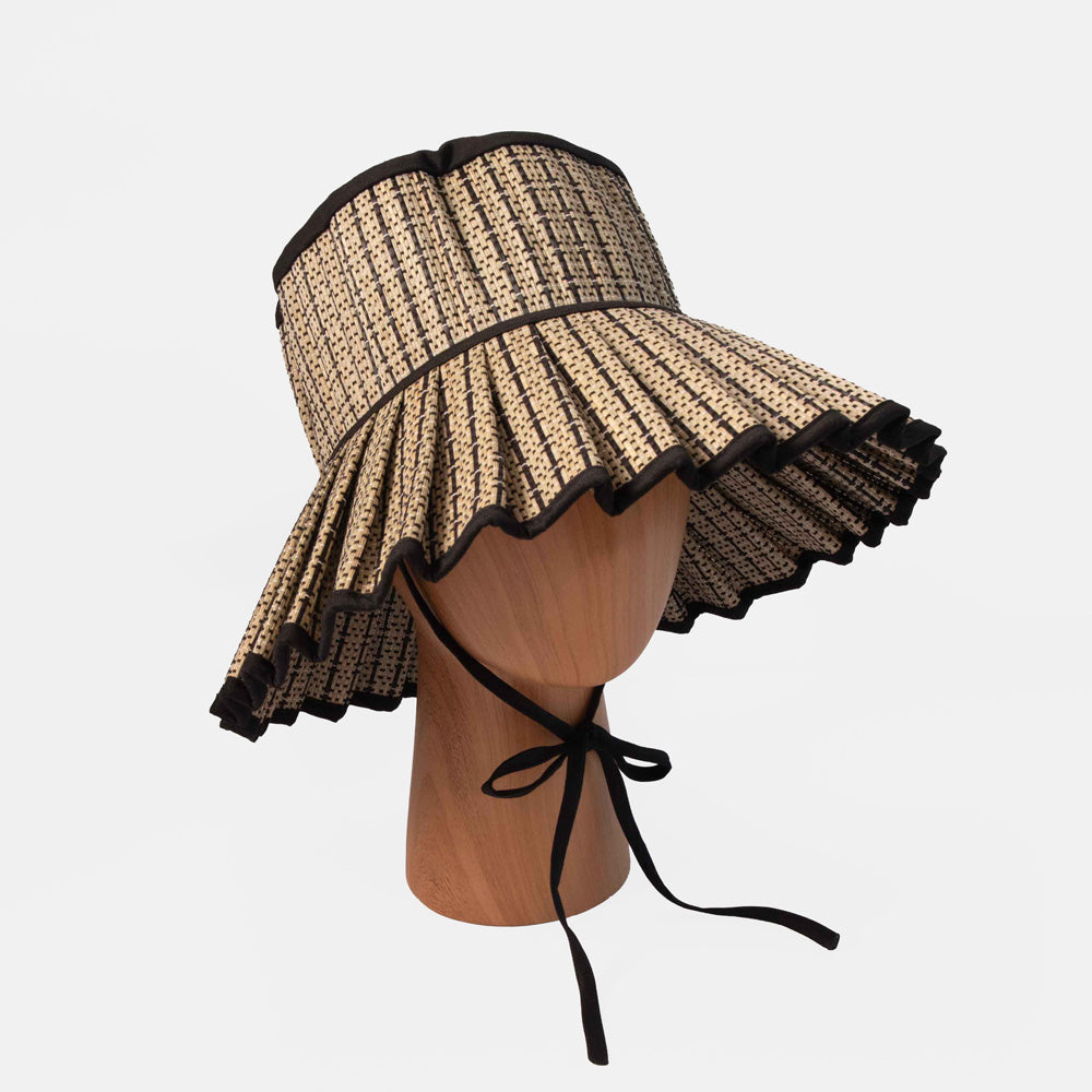 Woven sun hat with black trim on a mannequin head against a white background