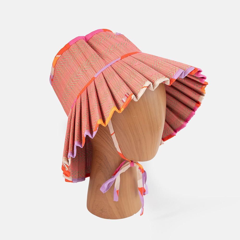 Colorful sun hat on a wooden mannequin head against a white background