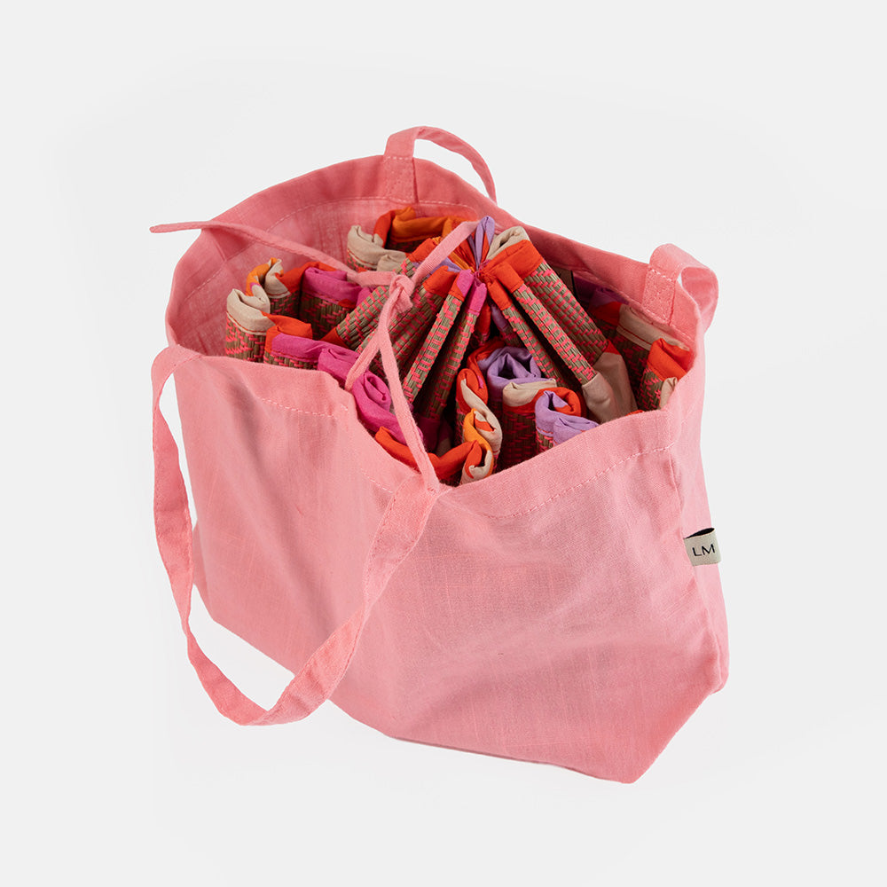 Pink bag filled with colorful ribbons on a white background