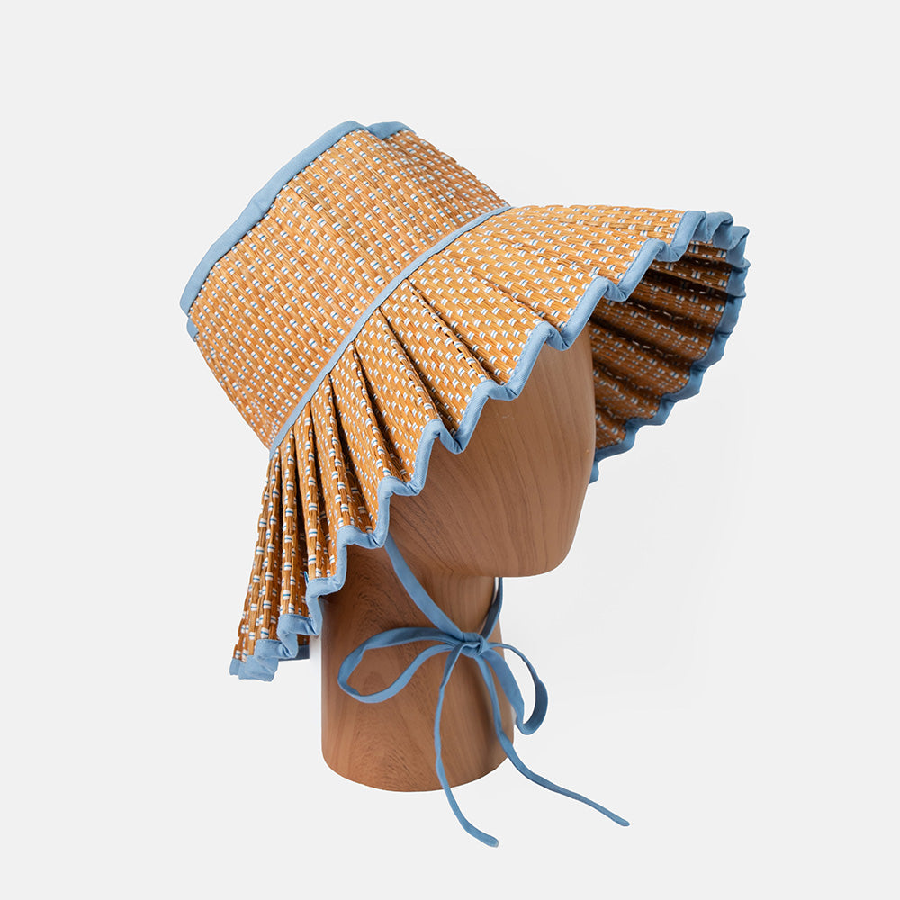 Yellow and blue patterned sun hat on a mannequin head against a light gray background