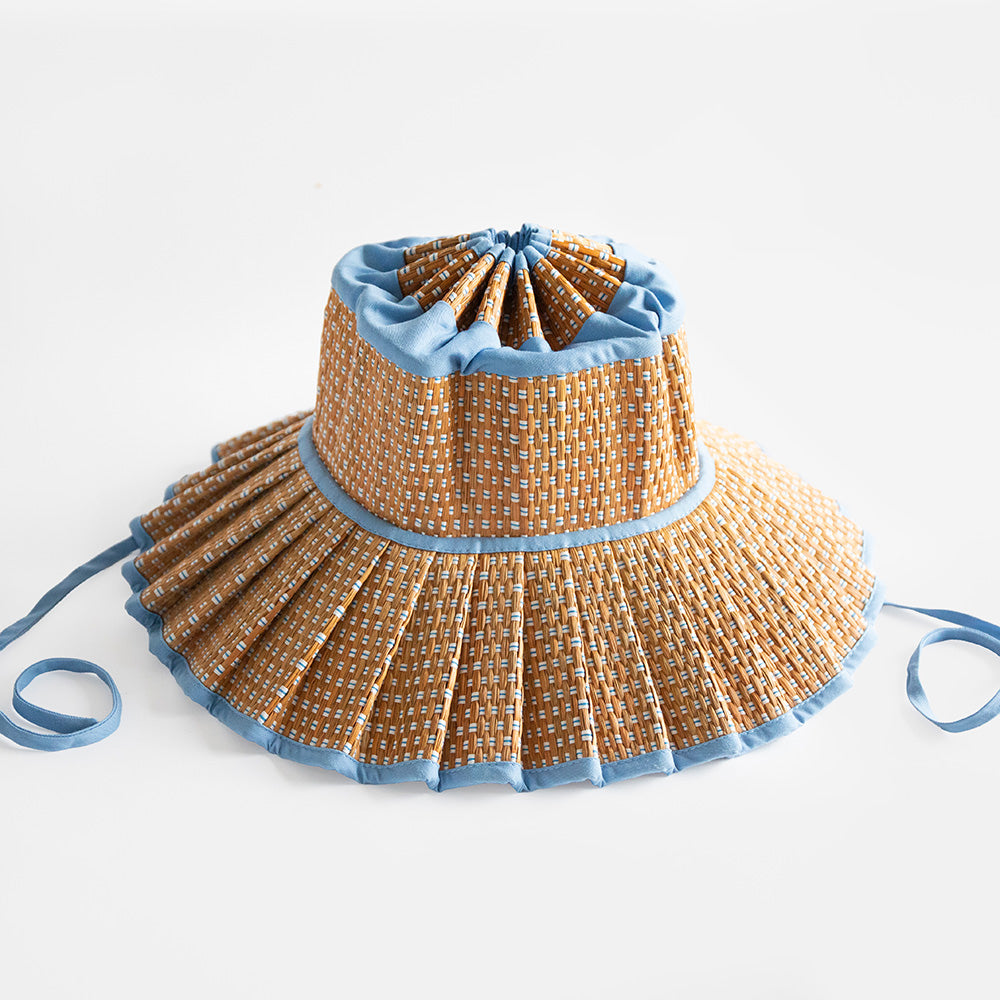 Yellow and blue patterned sun hat against a light gray background