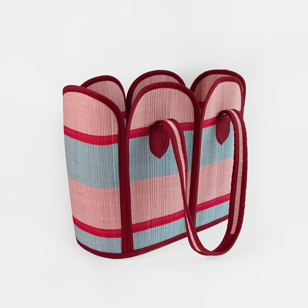Striped bag with red and pink handles on a white background