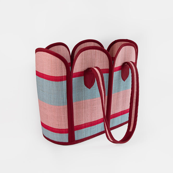 Striped bag with red and pink handles on a white background