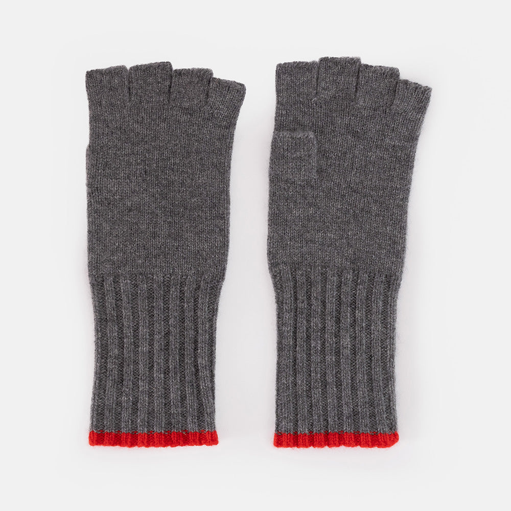 A pair of dark grey knitted cashmere fingerless gloves with long ribbed cuffs and a bright red trim, shown against a white background