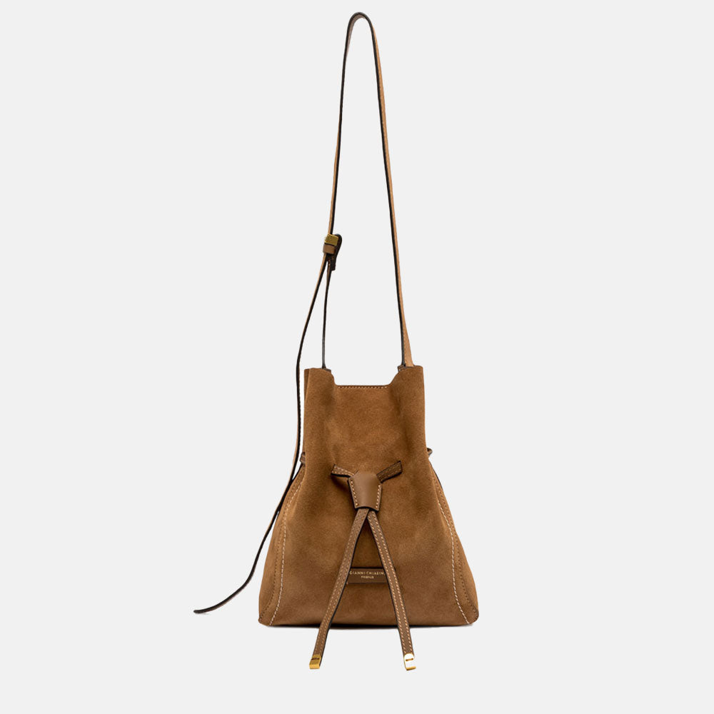 Brown suede handbag with a strap on a light grey background