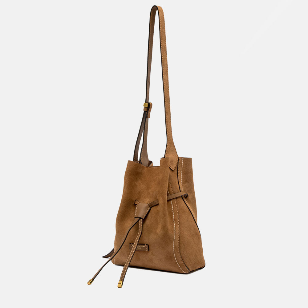 Brown suede handbag with a strap on a light grey background