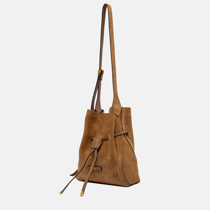 Brown suede handbag with a strap on a light grey background