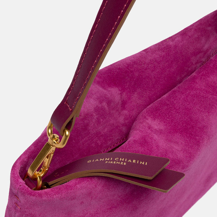 bright pink suede handbag with leather wrist and shoulder straps