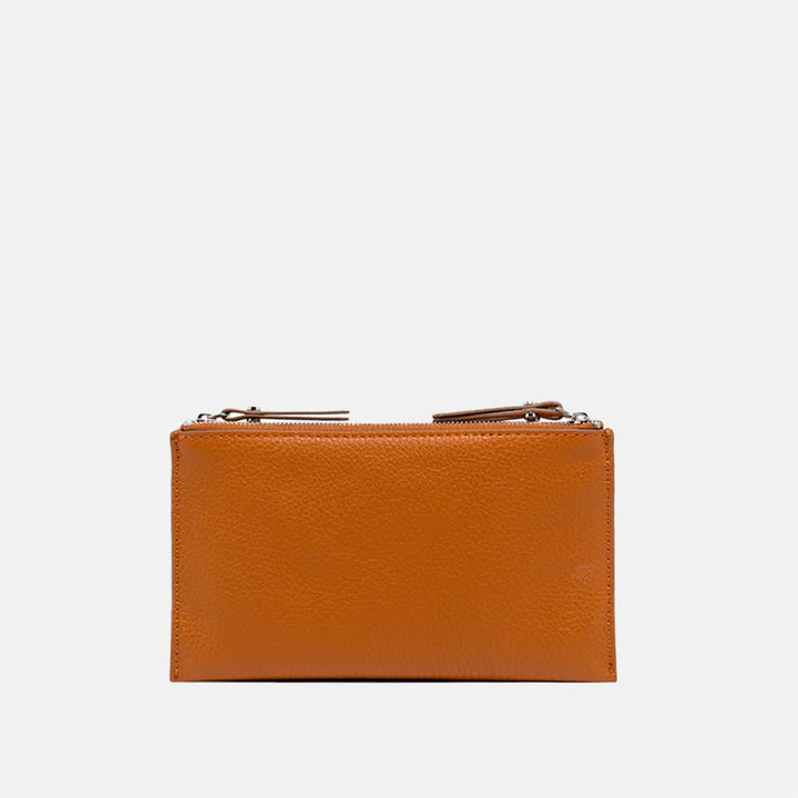orange leather crossbody bag on a light grey background
