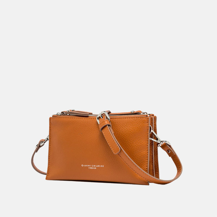 orange leather crossbody bag on a light grey background