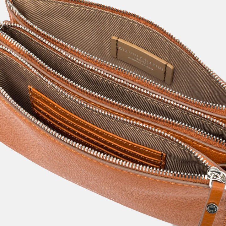 orange leather crossbody bag on a light grey background