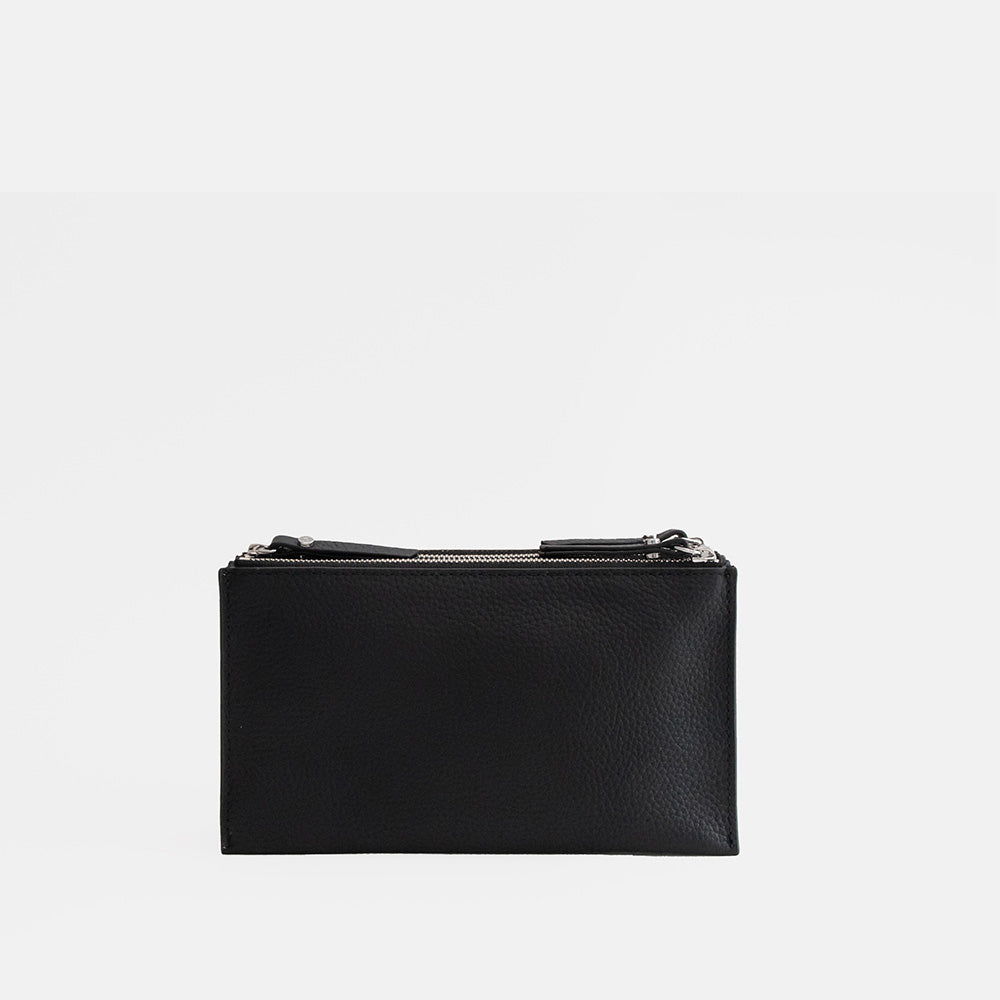 black leather envelope handbag on a light grey background