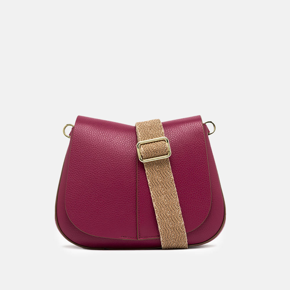 pink leather crossbody saddle bag with light brown webbing strap