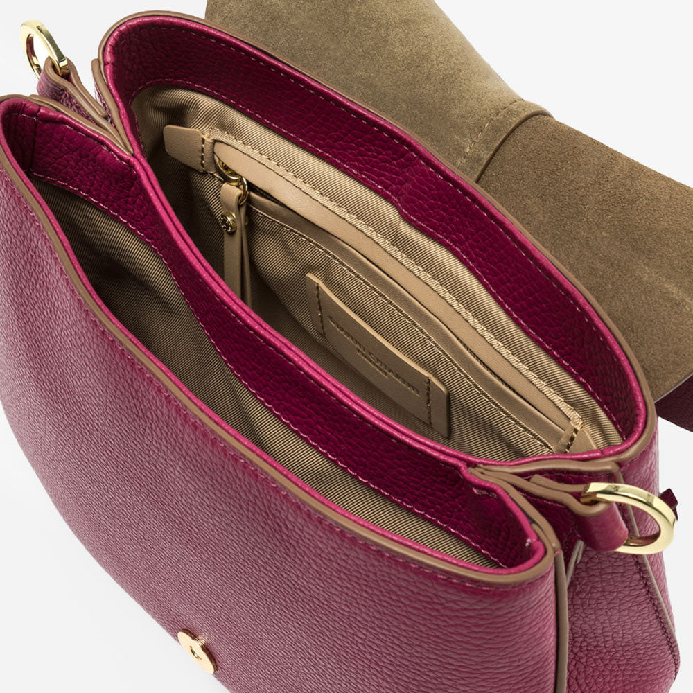 pink leather crossbody saddle bag with light brown webbing strap