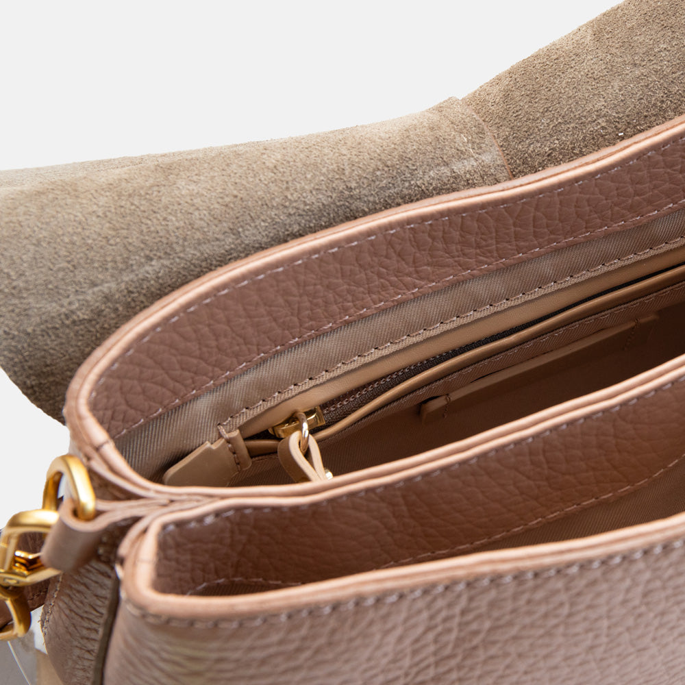 brown leather handbag internal with canvas lining on a light grey background