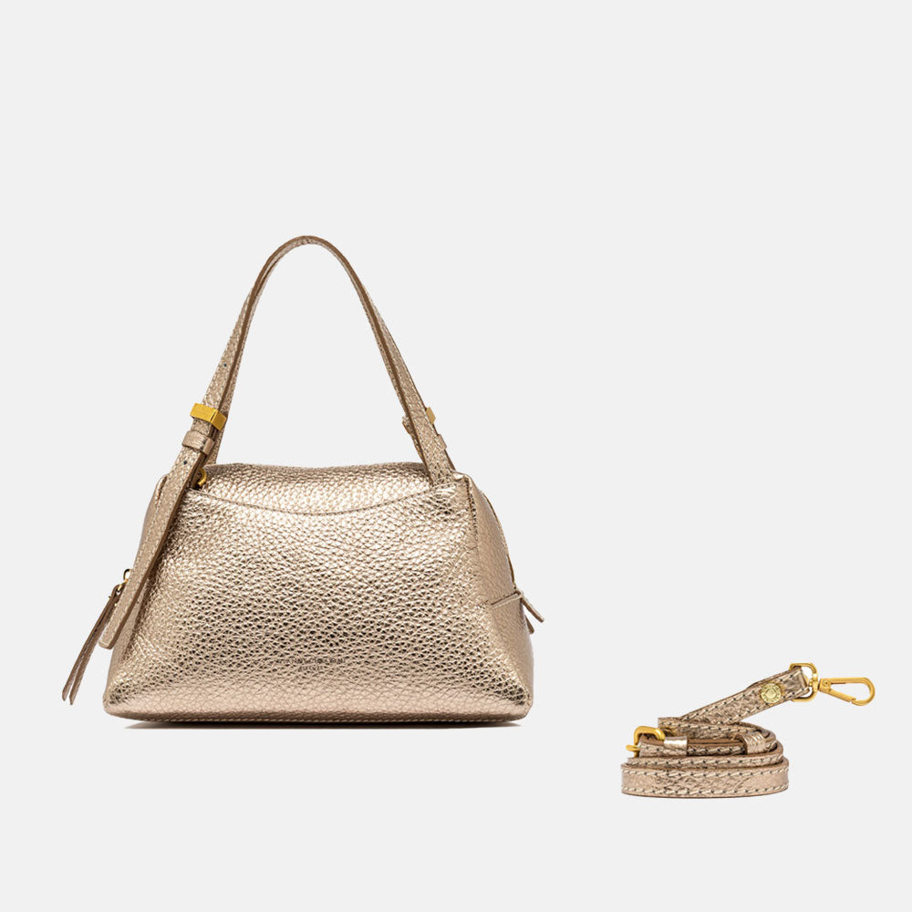 Gold handbag with matching strap on a light beige background