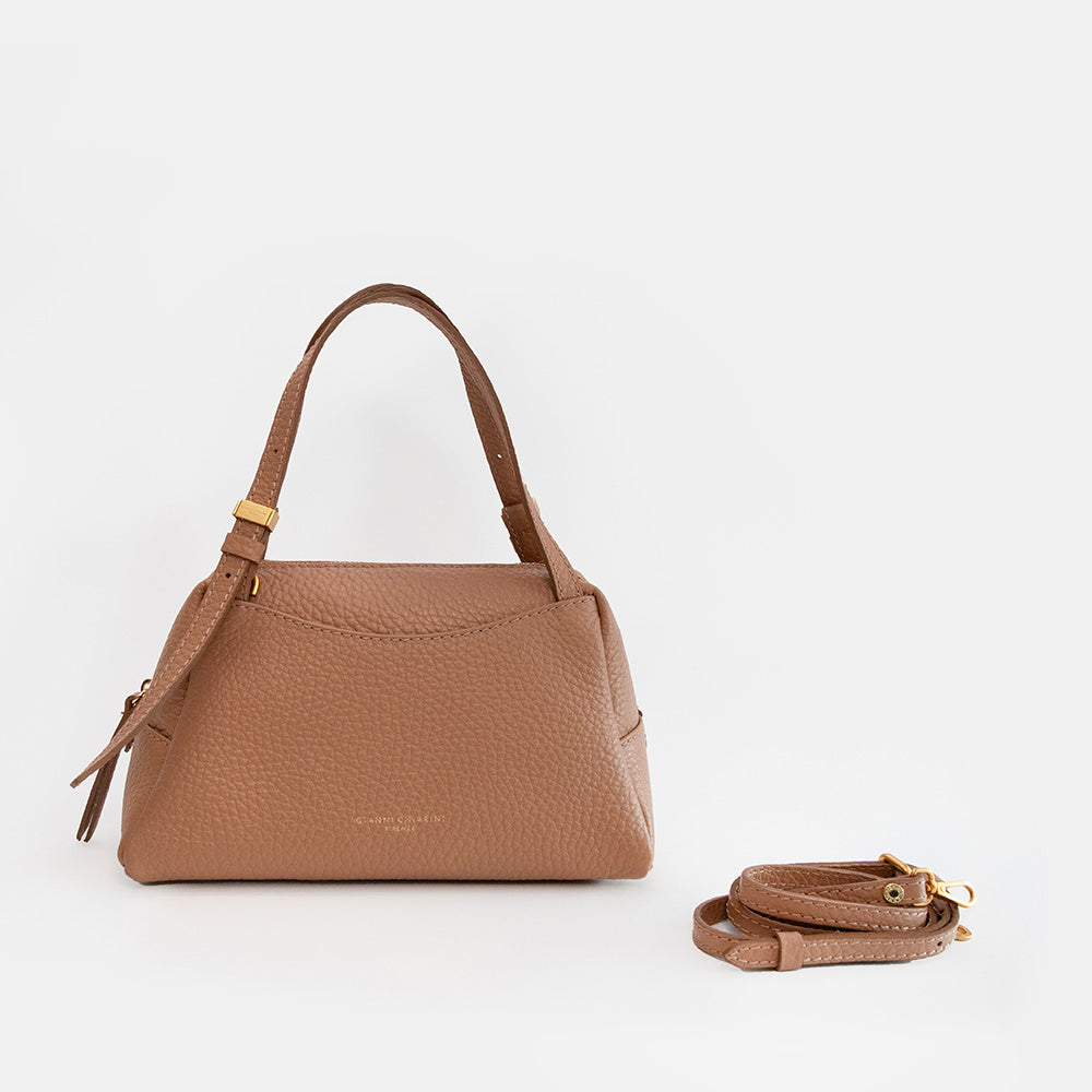 brown leather handbag with spare strap on a light grey background