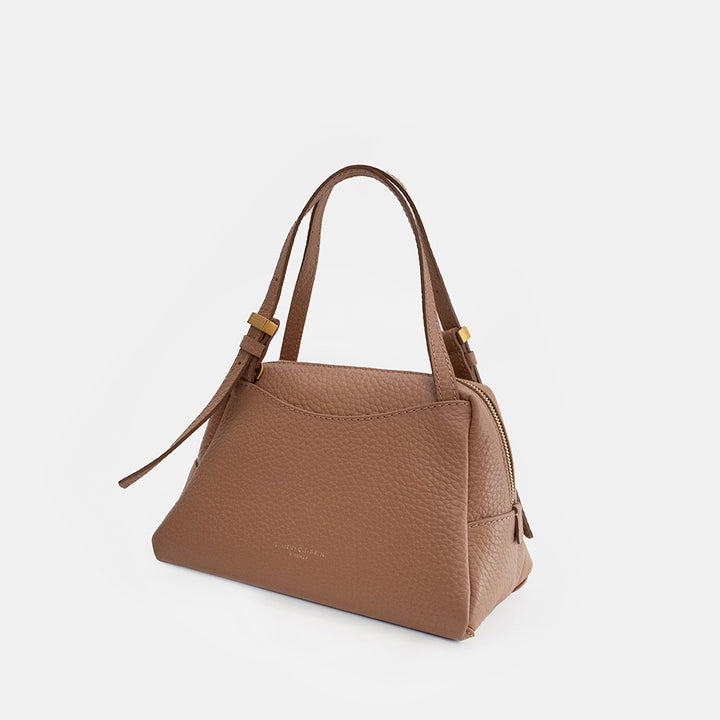brown leather handbag on a light grey background