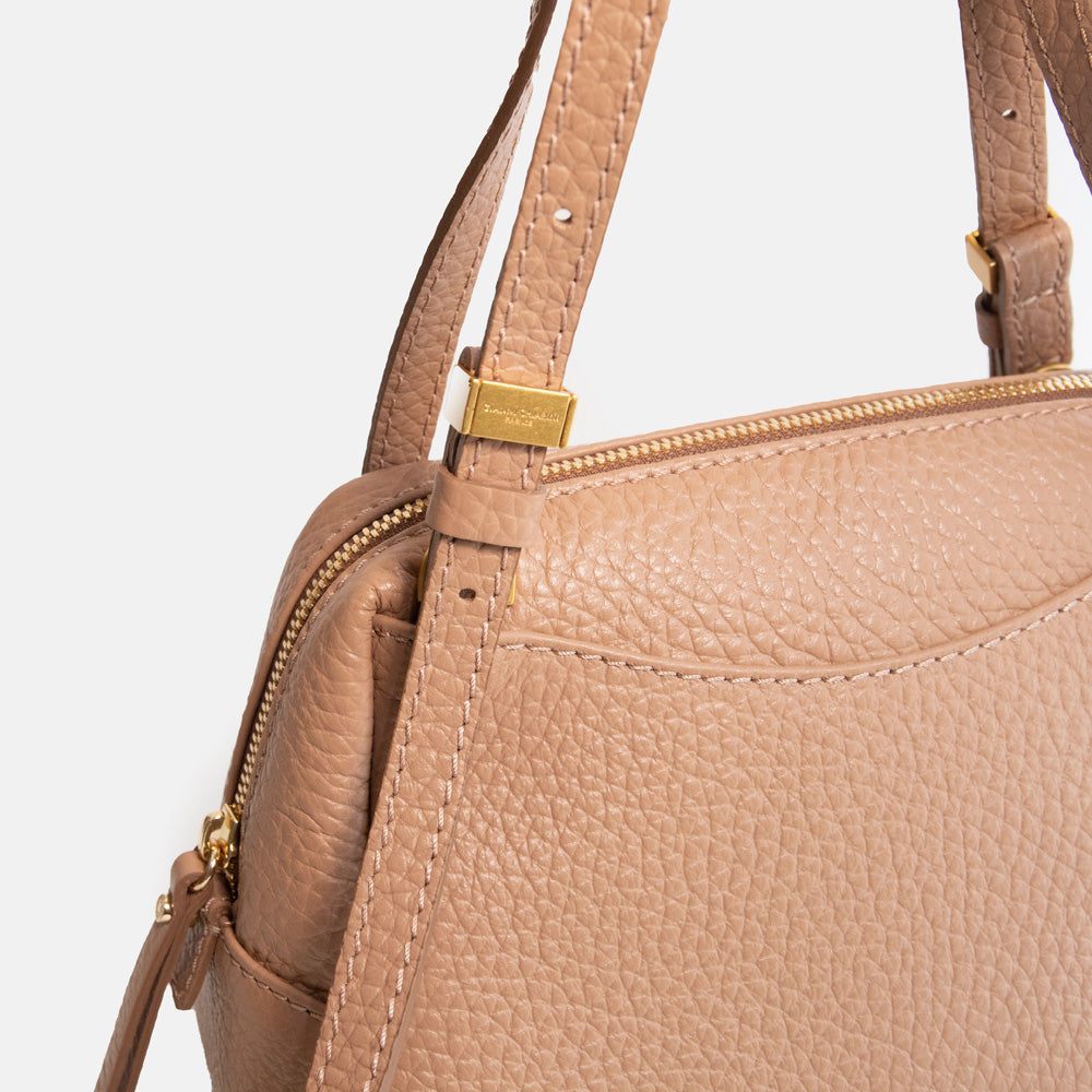 brown leather handbag on a light grey background