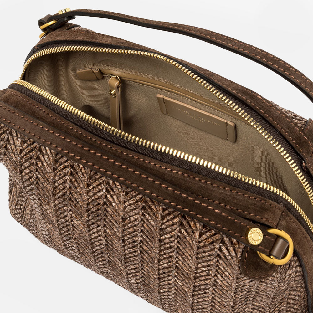 Dark brown woven straw handbag with a strap on a light grey background
