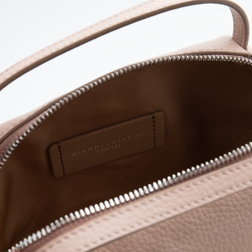 light pink leather handbag with canvas internal lining on a light grey background