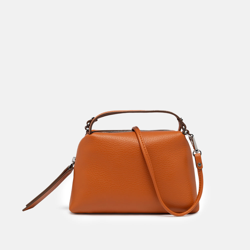 orange leather handbag on a light grey background