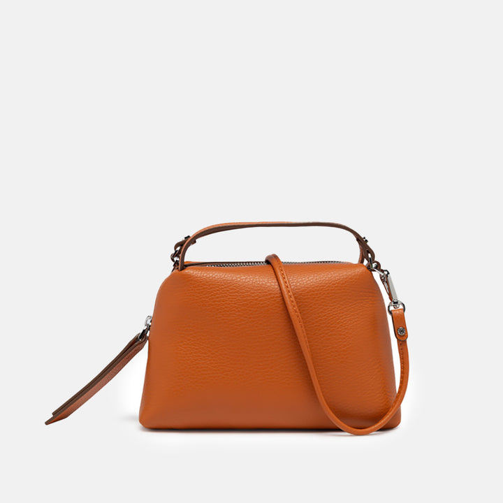 orange leather handbag on a light grey background