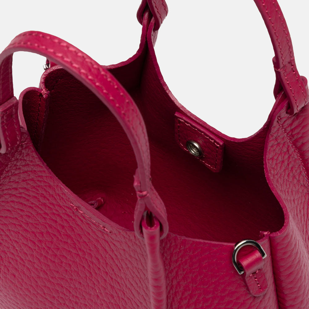 Pink handbag with matching strap on a white background