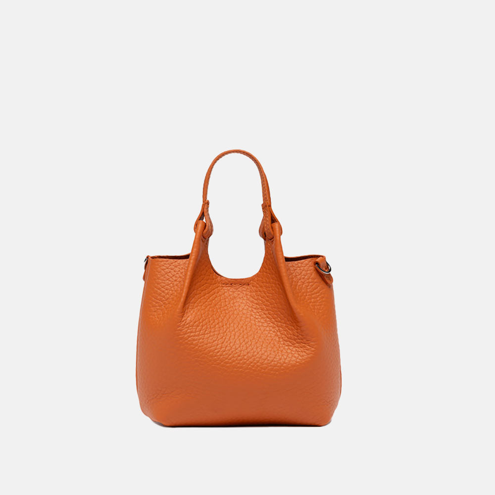 orange leather handbag on a light grey background