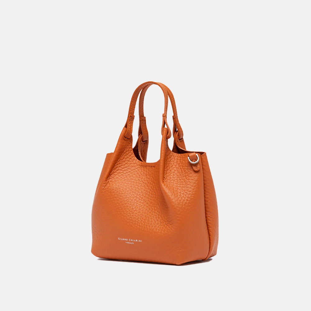 orange leather handbag on a light grey background
