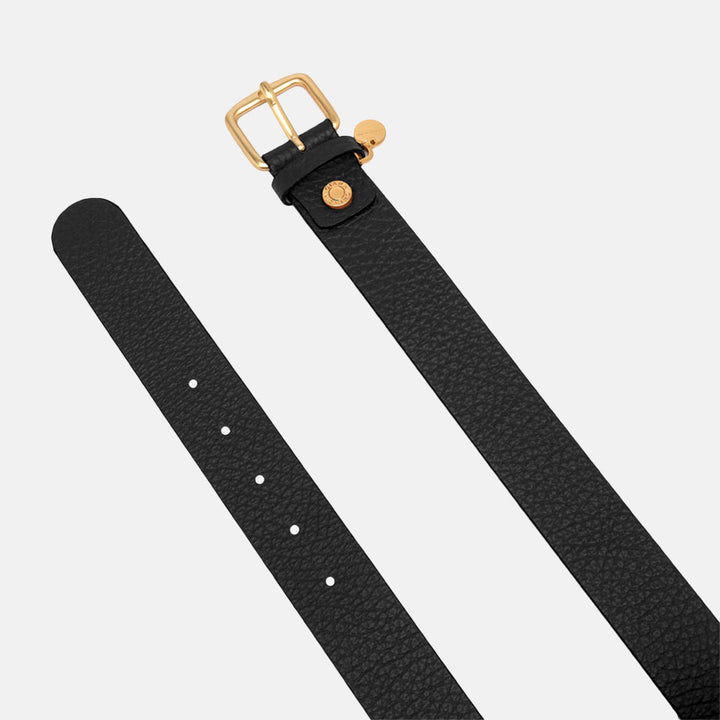 Black leather belt with gold buckle and charms on a light grey background