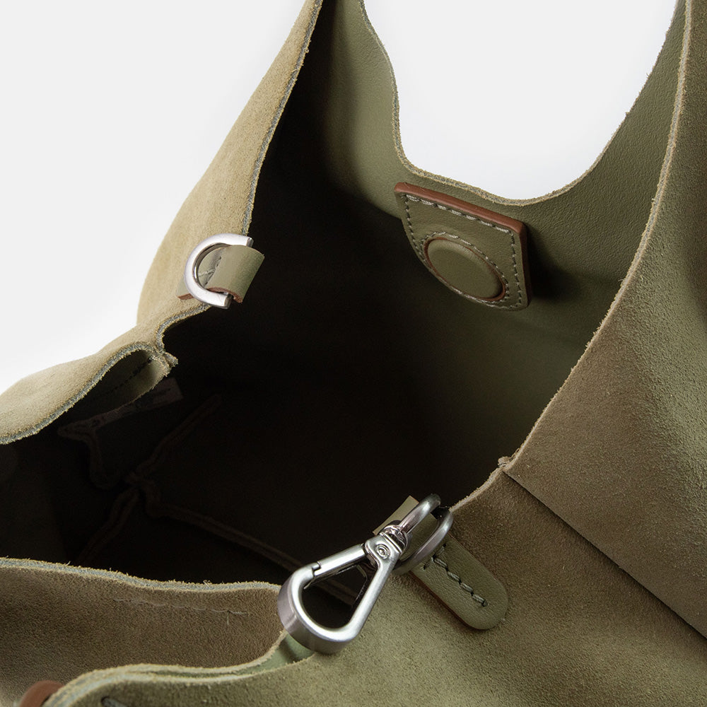 Close-up of a green suede handbag on a white background