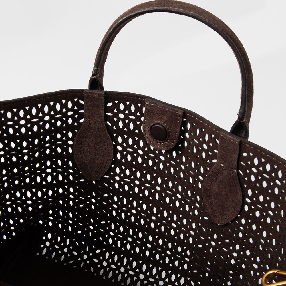 Brown suede handbag with a patterned design on a white background