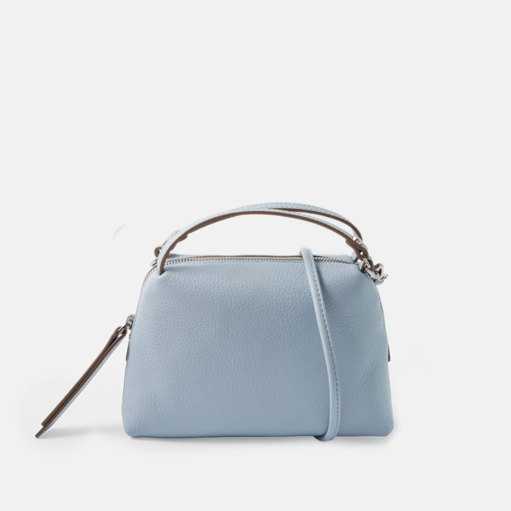 light blue leather small handbag with grab handles and removable crossbody strap on a white background