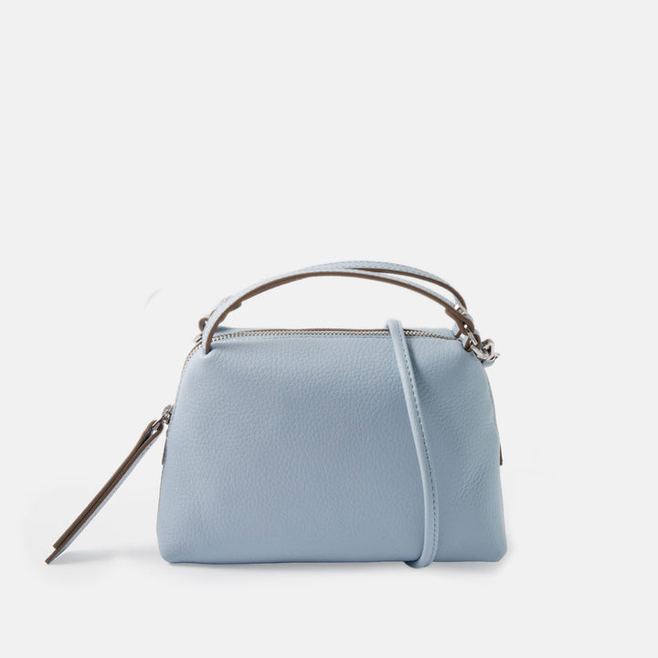 light blue leather small handbag with grab handles and removable crossbody strap on a white background